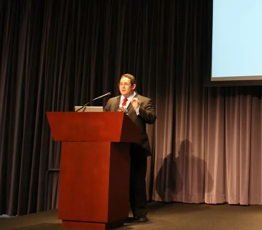 Ariel Coro delivering a keynote at a podium